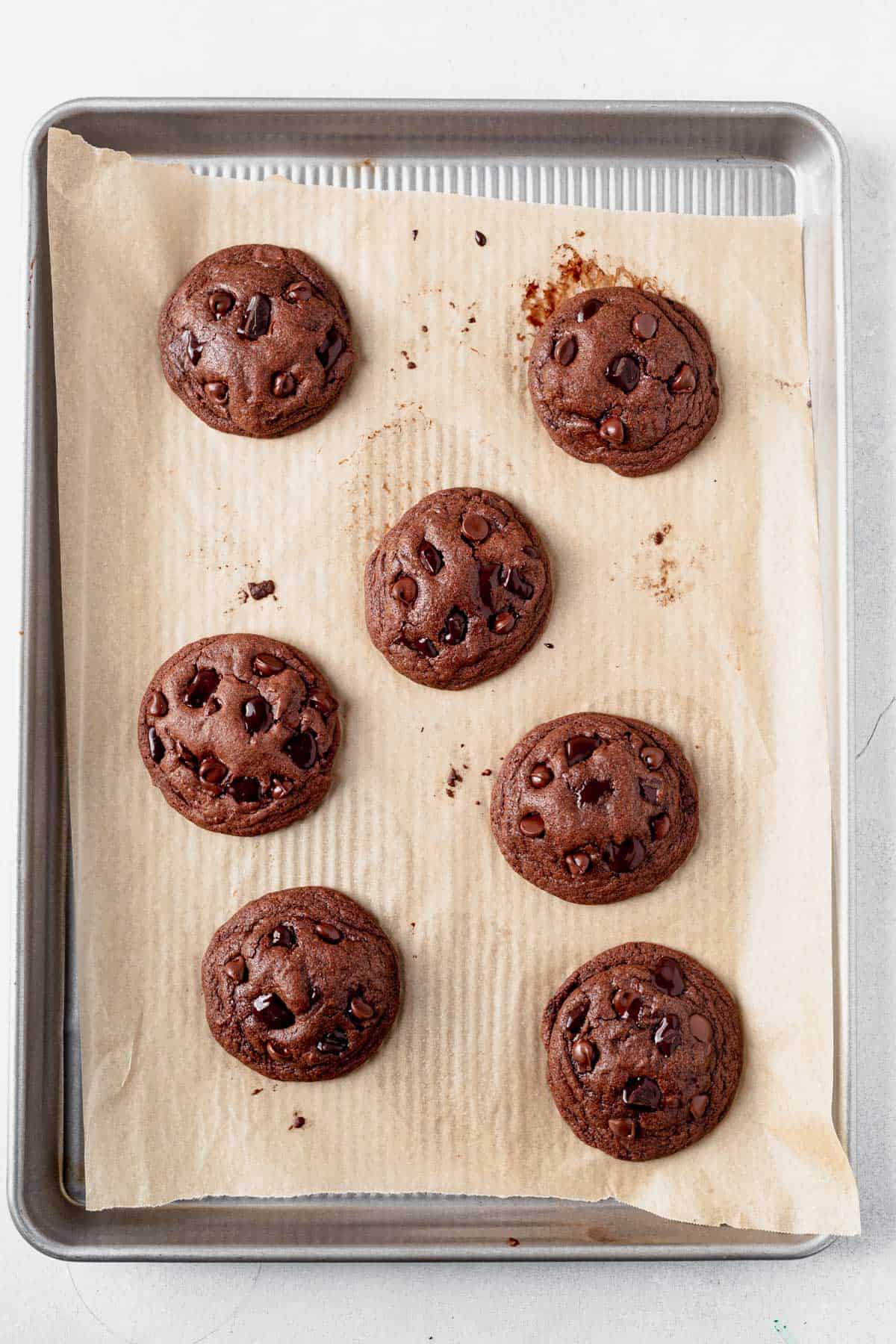 freshly baked chocolate pudding cookies cooling on a cookie sheet.