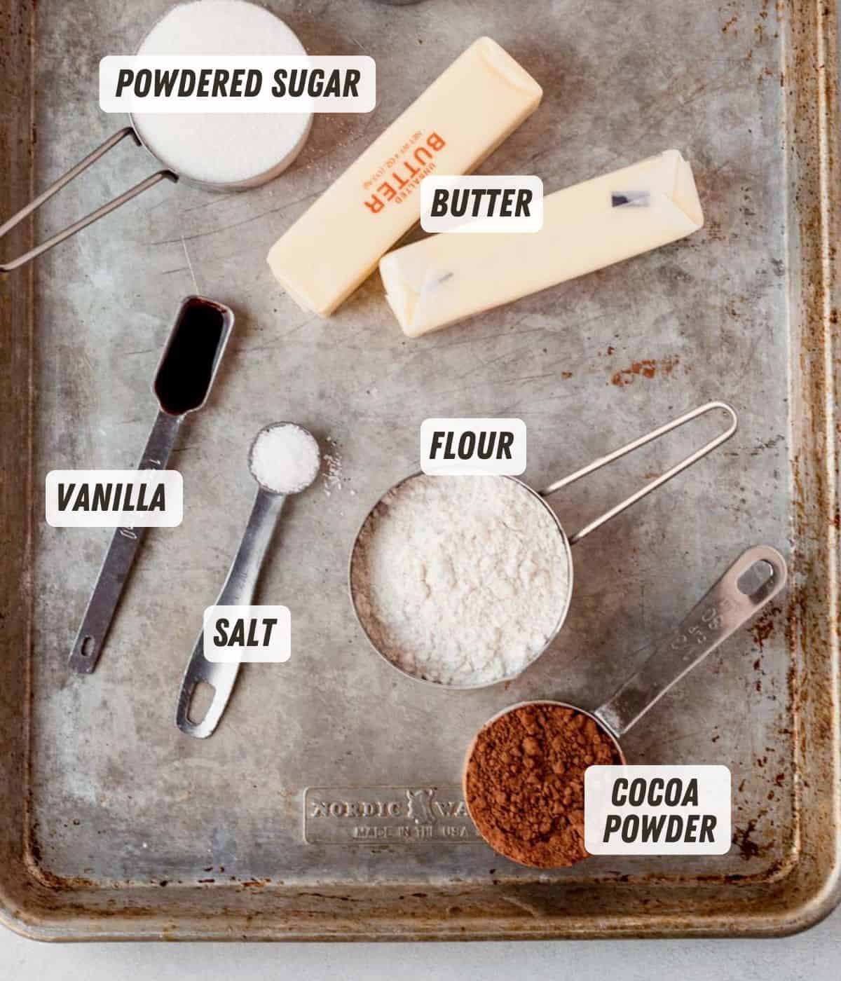 cocoa powder, butter, flour, powdered sugar, vanilla and salt on a baking sheet