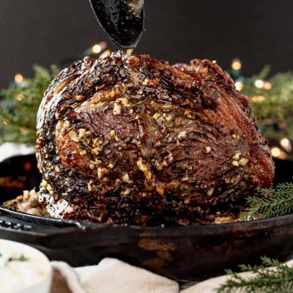 standing prime rib roast with garlic herb crust in a skillet