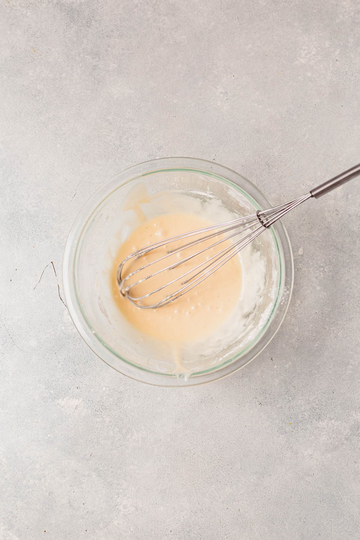 eggnog icing in a bowl with a whisk.