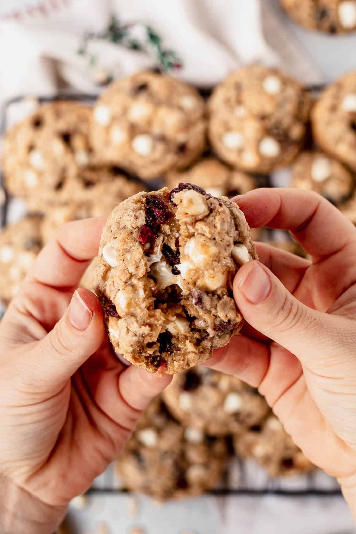 breaking a white chocolate cranberry oatmeal cookie in half