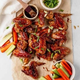 asian chicken wings on parchment paper with celery and carrots