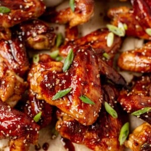 a platter of crispy juicy chicken wings with green onion