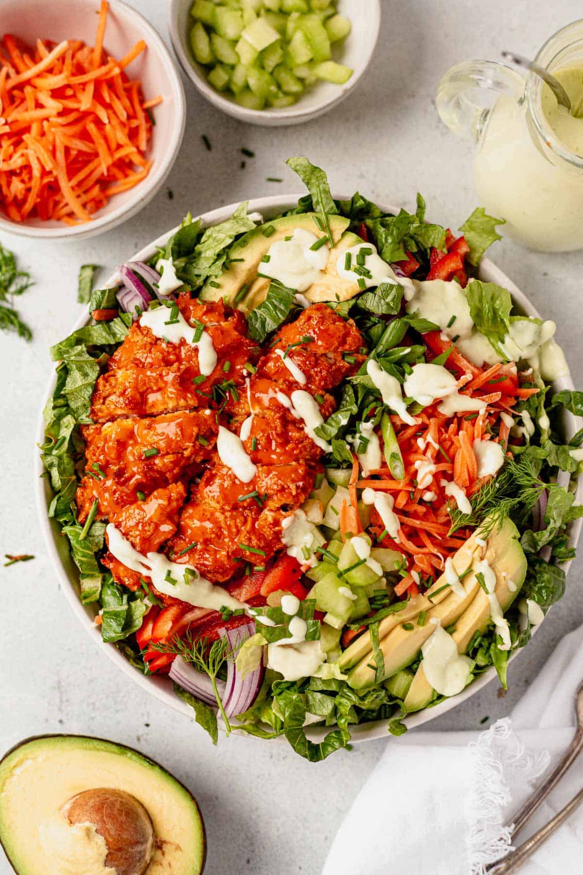 avocado ranch dressing drizzled on top of buffalo chicken salad