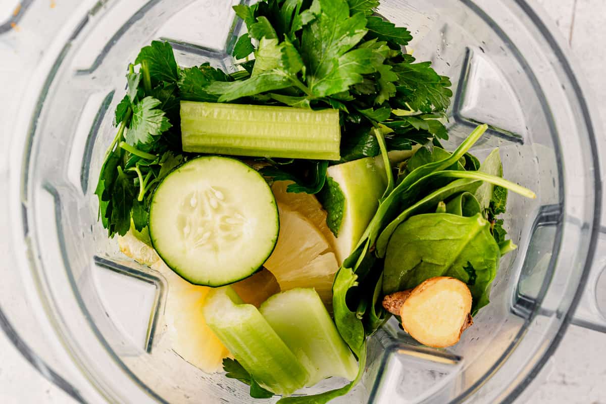 celery, cucumber, apple, parsley, mint, ginger, and pineapple in a blender