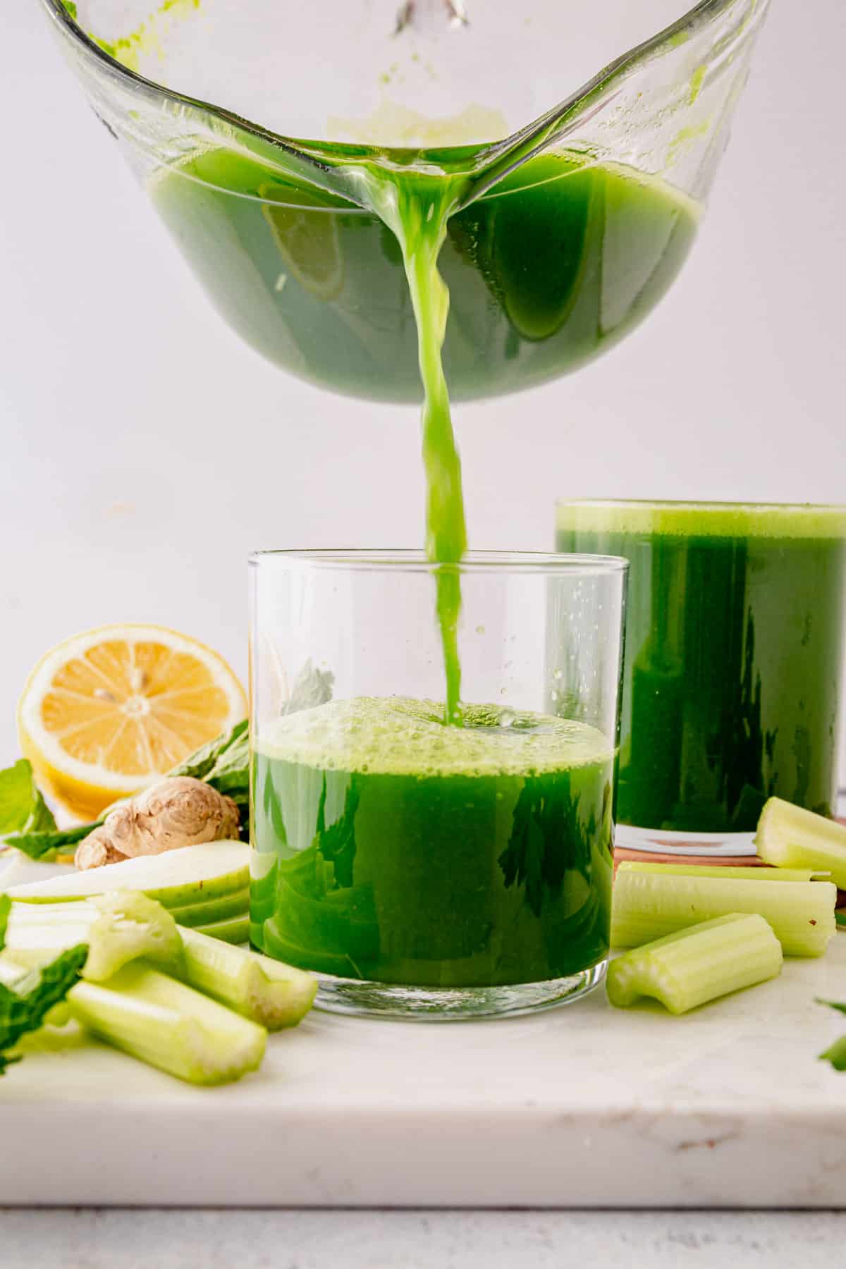 pouring green juice into a cup