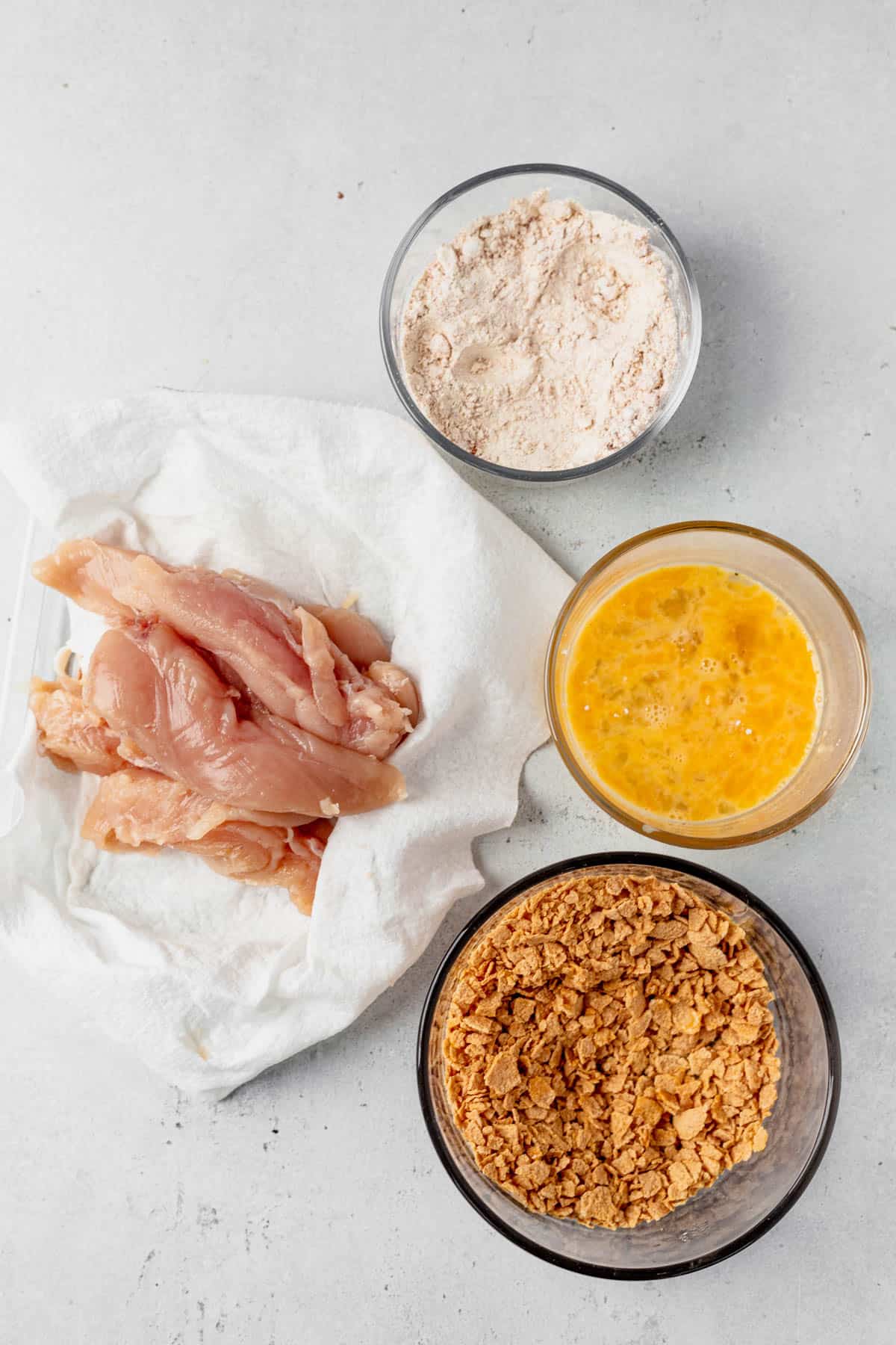 flour, egg, cornflakes and chicken for buffalo chicken tenders