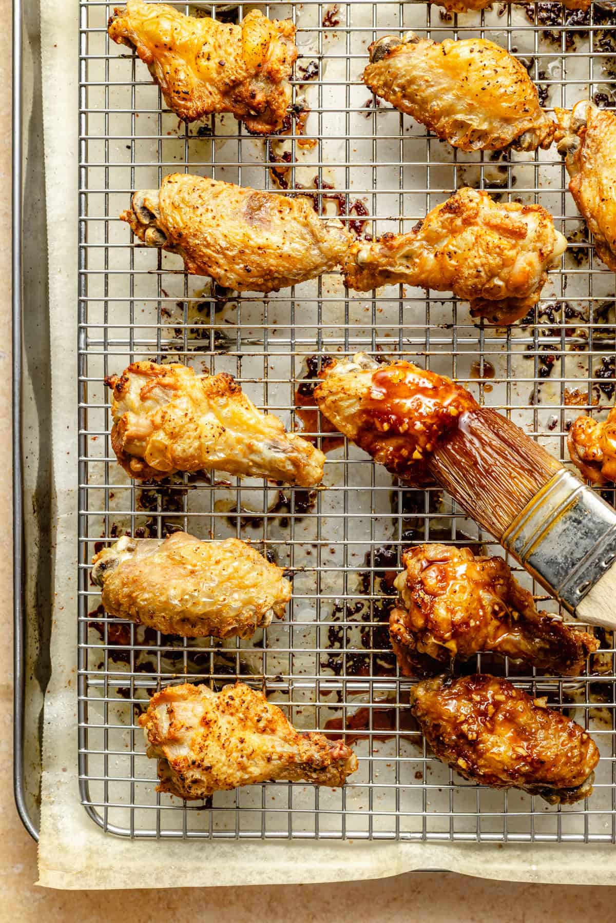 brushign asian sauce onto a crispy chicken wing.