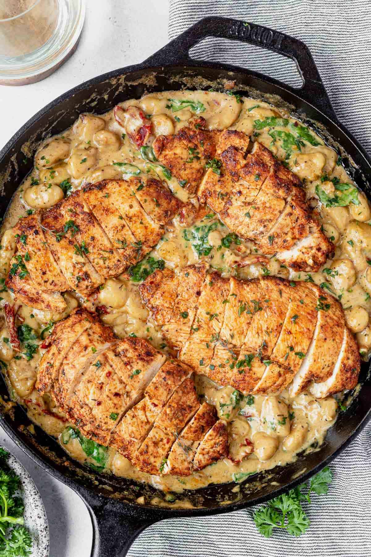 pan fried chicken on top of creamy gnocchi with spinach