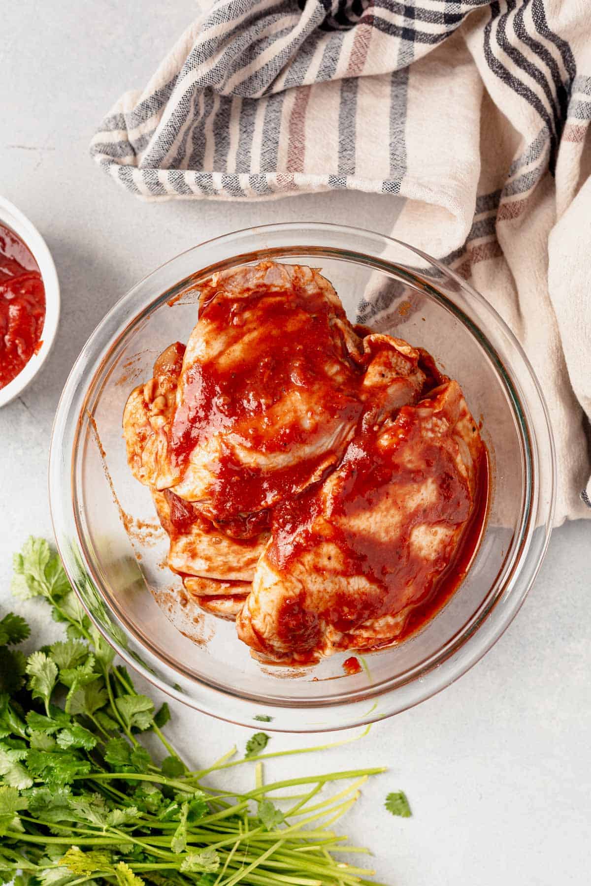 chicken thighs marinating in spices and bbq sauce