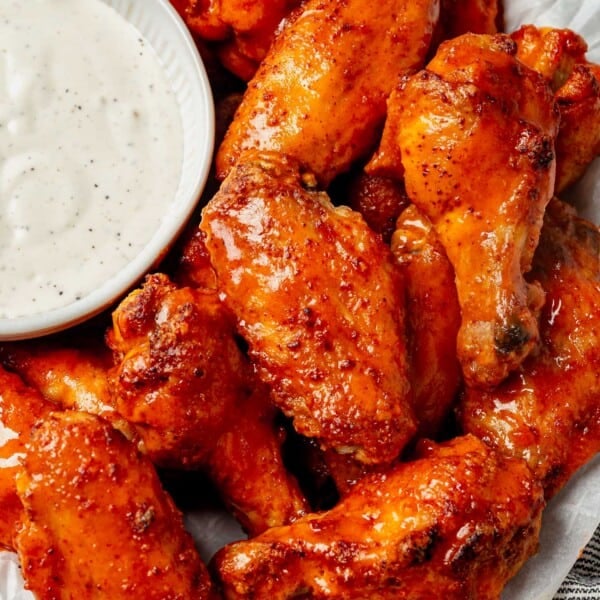 a plate of crispy chicken wings with a side of ranch
