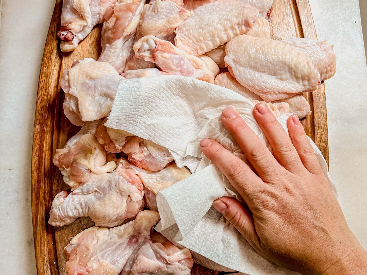 patting chicken wings dry with paper towels