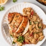 dinner plate of one pan creamy chicken and gnocchi on a counter with lemons and skillet