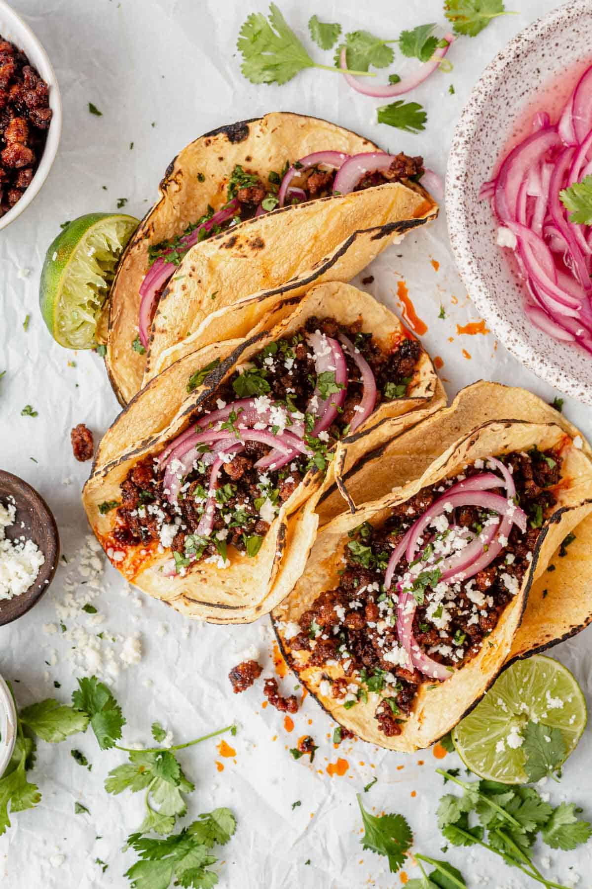 tacos with ground pork, cilantro, lime and pickled onion
