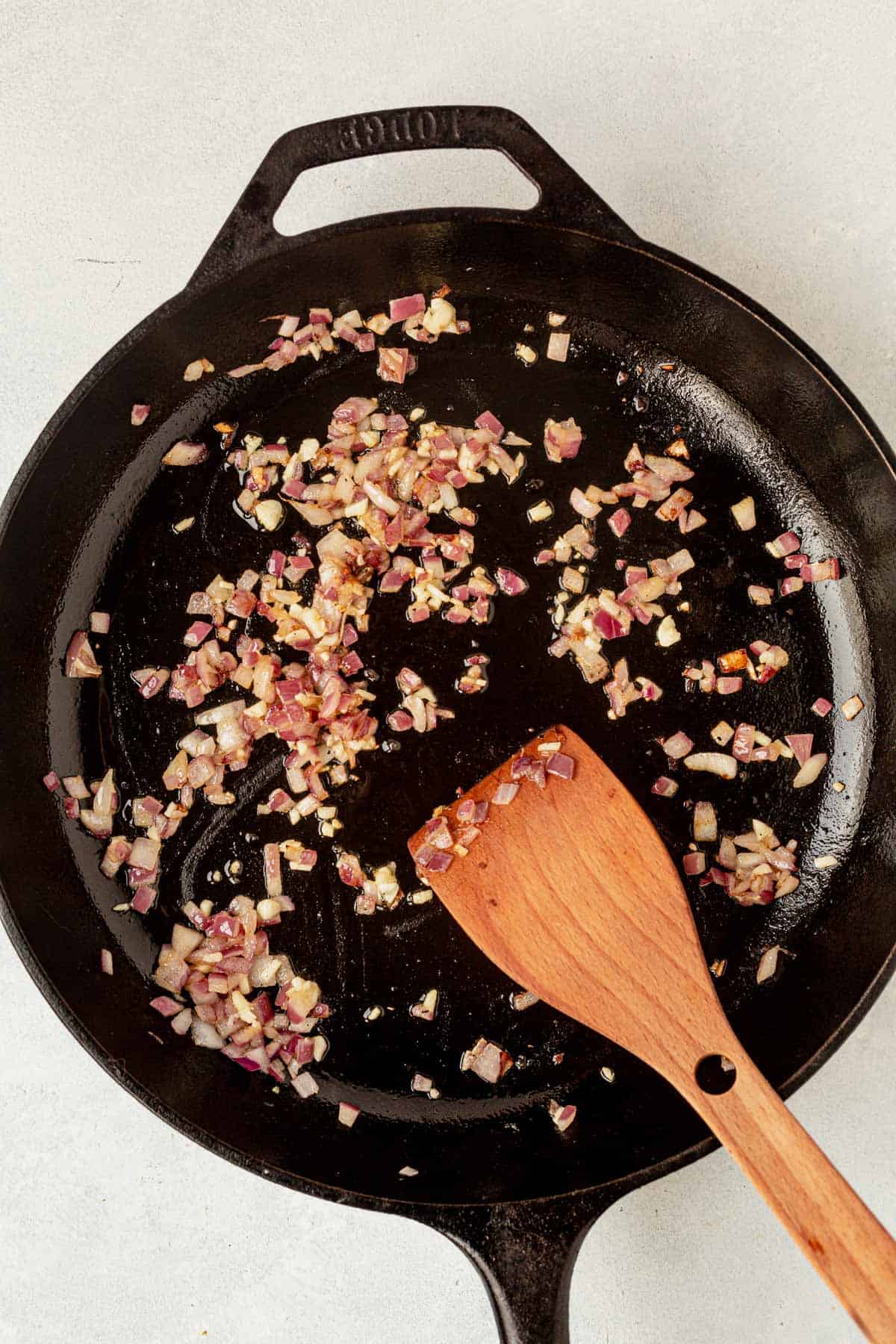 red onion and garlic cooking in a skillet