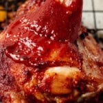 brushing bbq sauce onto baked bbq chicken thighs.