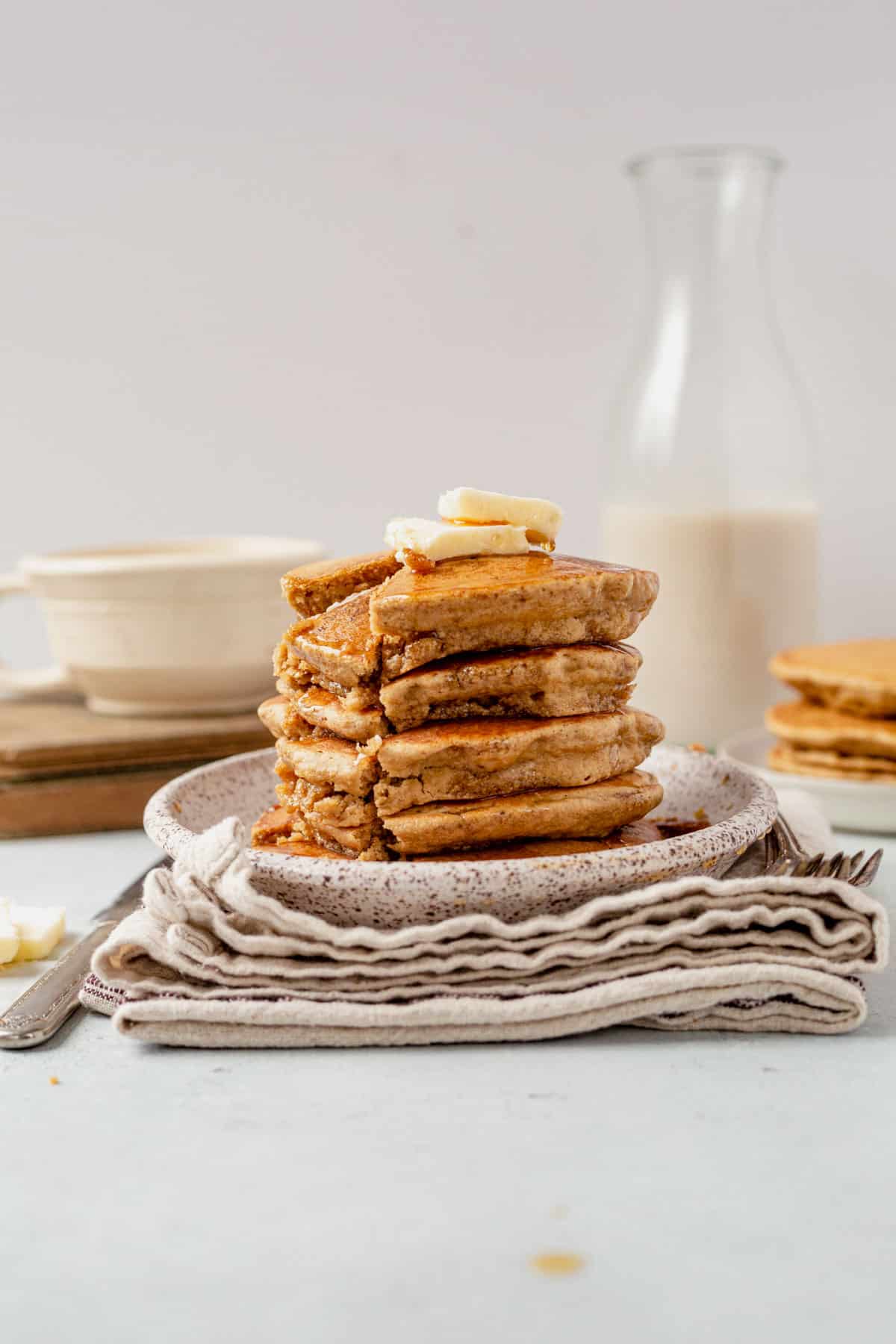 taking a bite out of a stack of oat flour pancakes