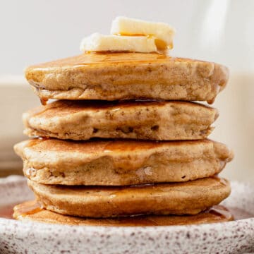 syrup dripping off a stack of oat flour pancakes