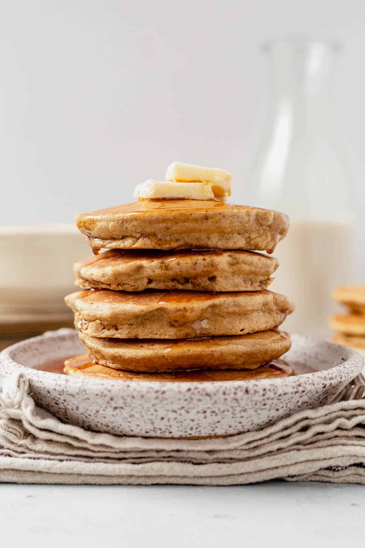 syrup dripping off of a stack of oat flour pancakes