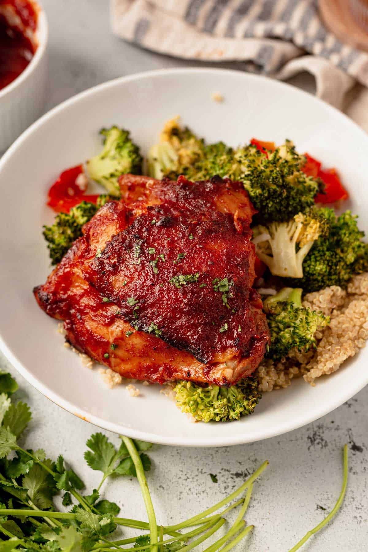 bbq chicken thigh in a bowl with veggies