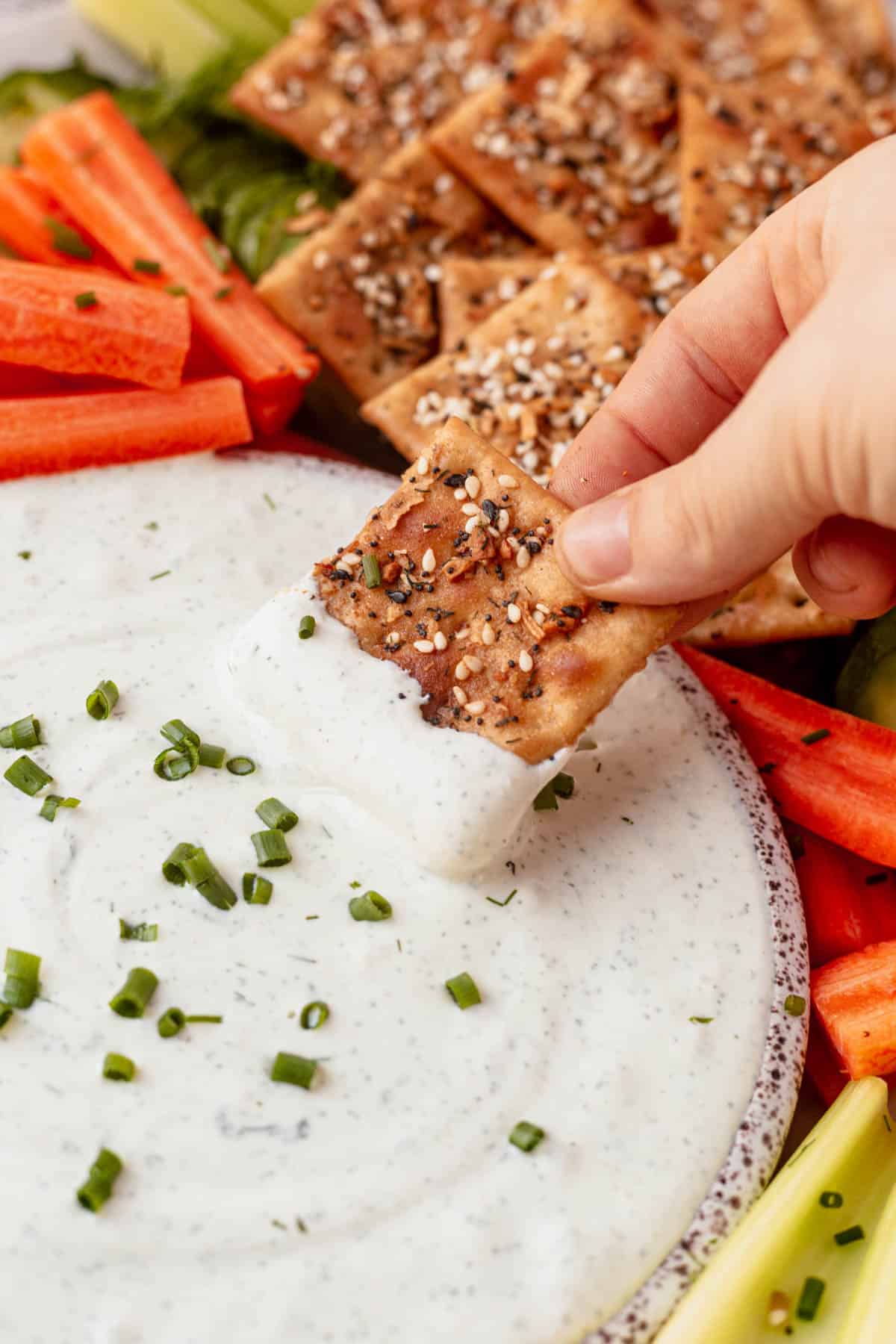 dipping a cracker into cottage cheese dip
