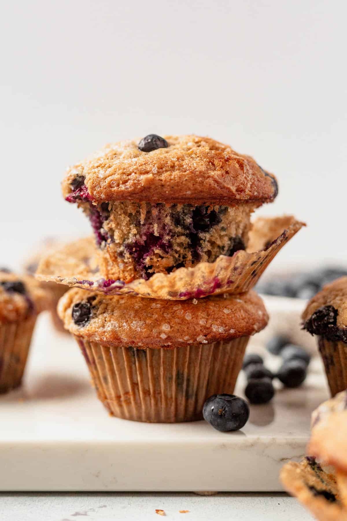 two banana blueberry muffins stacked on a countertop