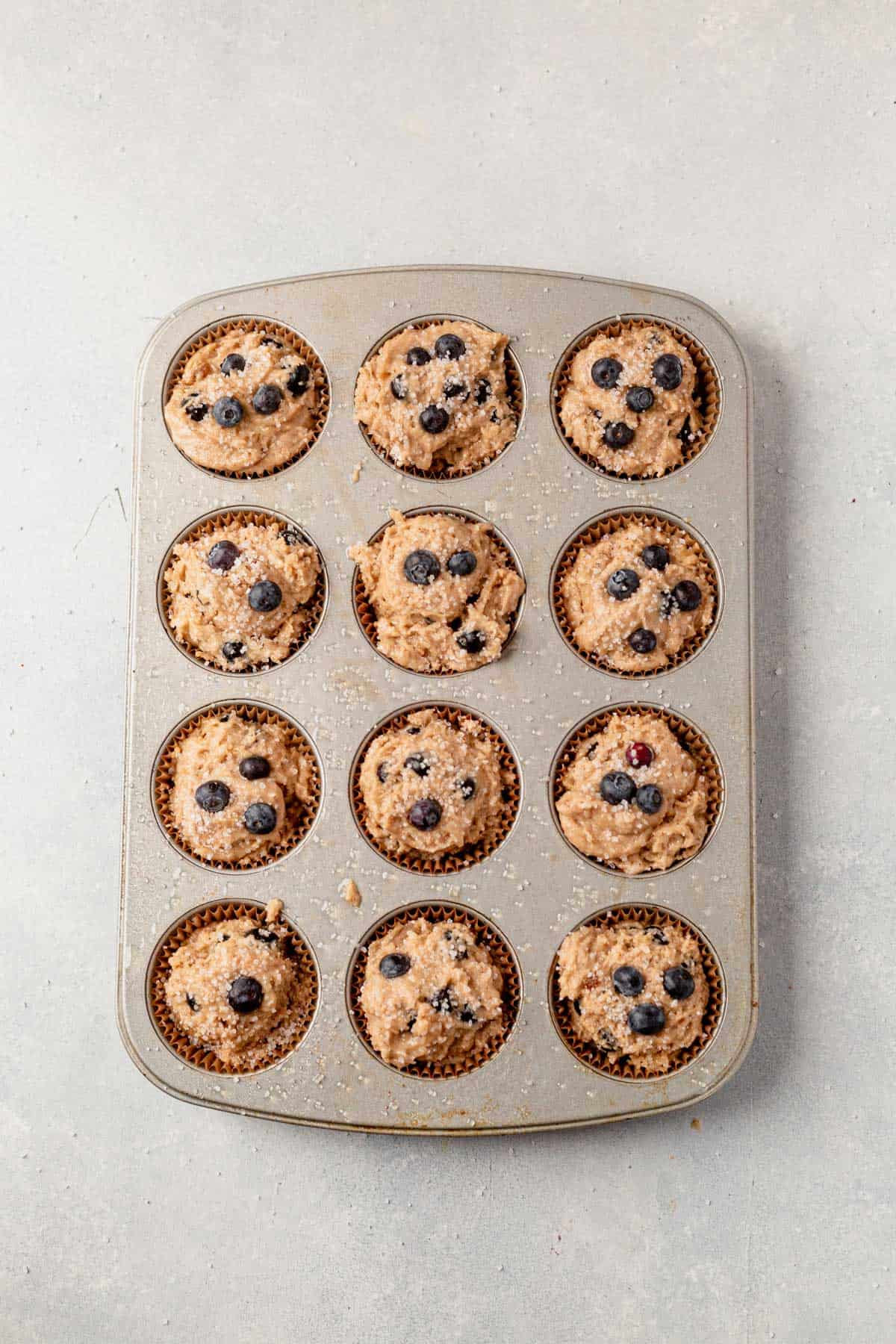 banana blueberry muffin batter in muffin tins