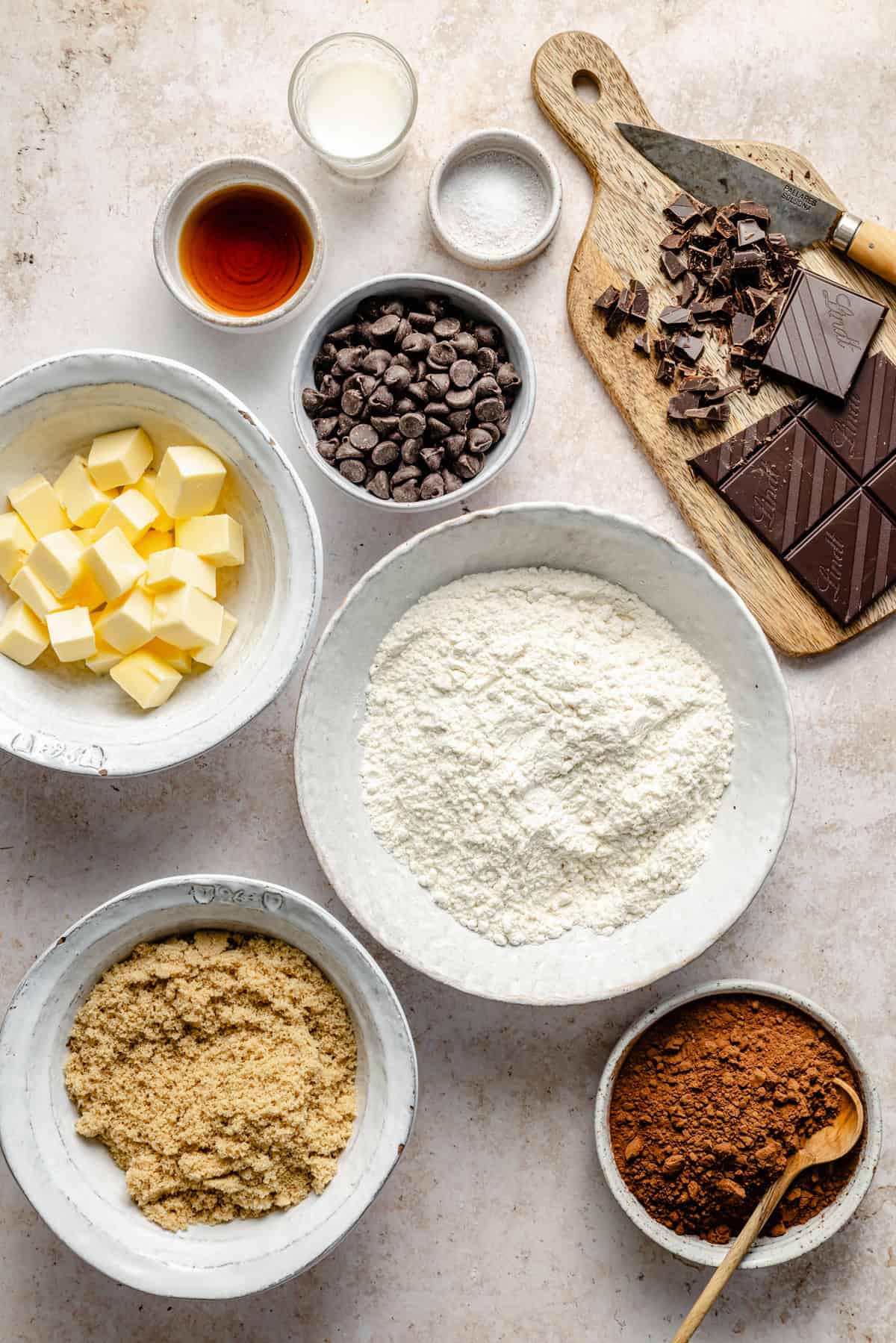 cubed butter, brown sugar, flour, cocoa powder, chocolate chips, milk, and vanilla on a counter top for edible brownie batter.