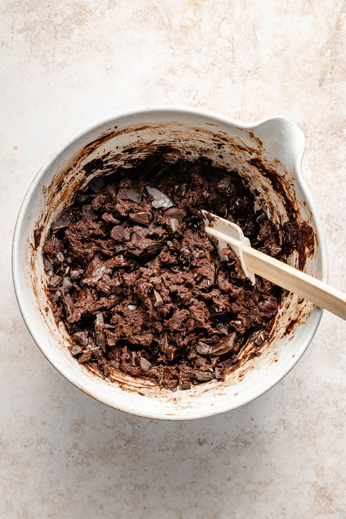 stirring chocolate chips into edible brownie batter.