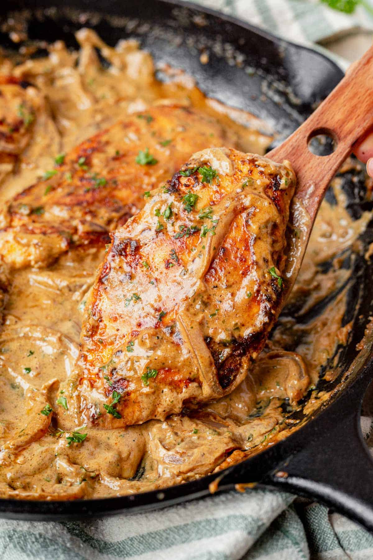 spatula scooping Boursin chicken out of a skillet