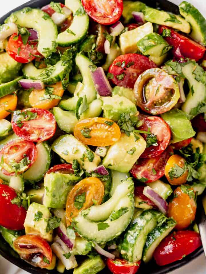 cucumber tomato avocado salad in a serving bowl