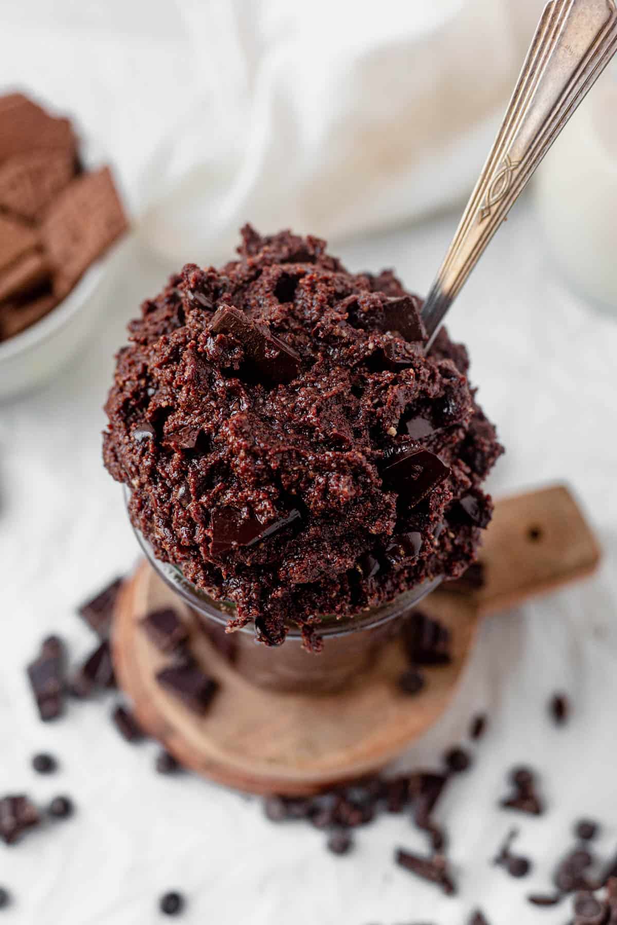 edible brownie batter in a cup with a spoon