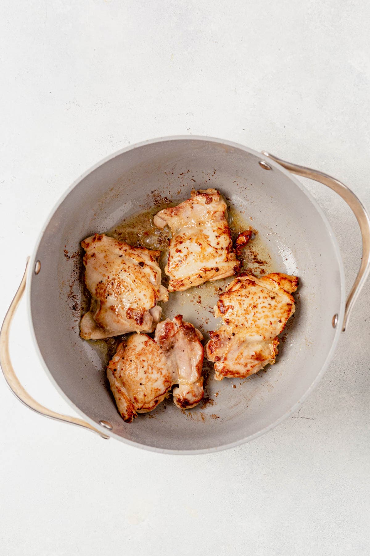 seared chicken thighs in a large pot