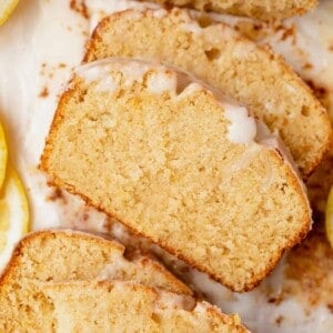 two pieces of gluten-free lemon drizzle cake on parchment paper