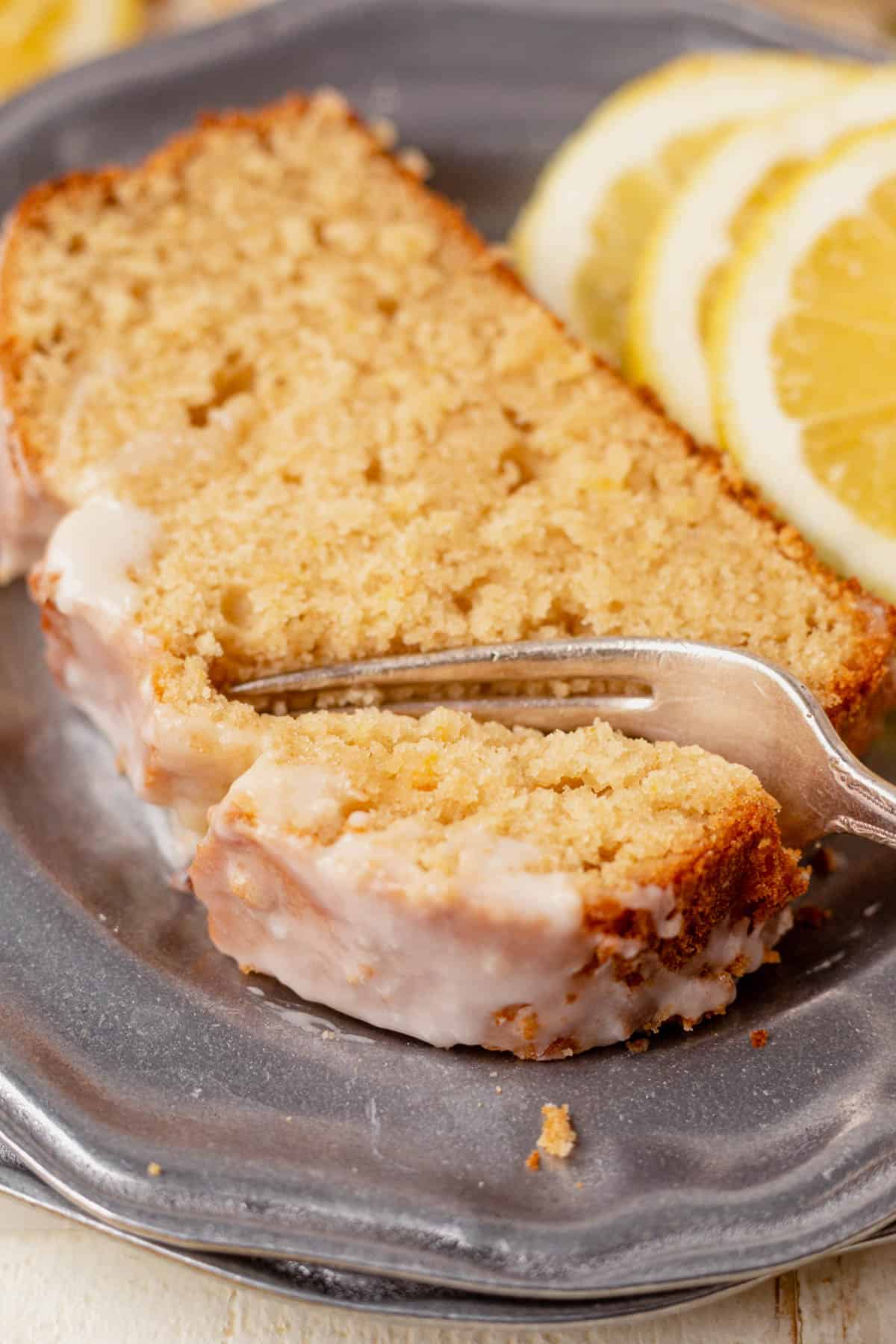 fork cutting into a piece of gluten-free lemon drizzle cake