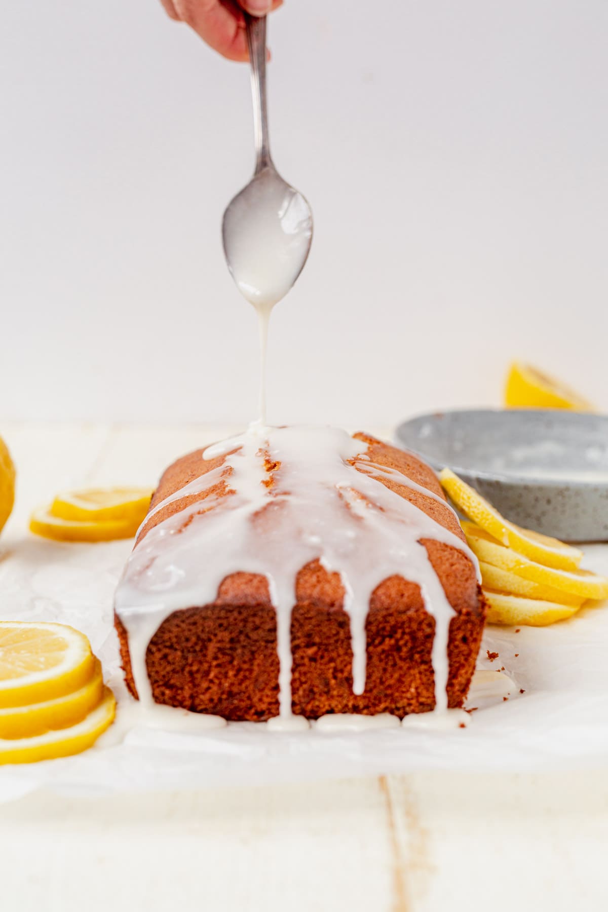 drizzling icing on top of gluten-free lemon loaf cake
