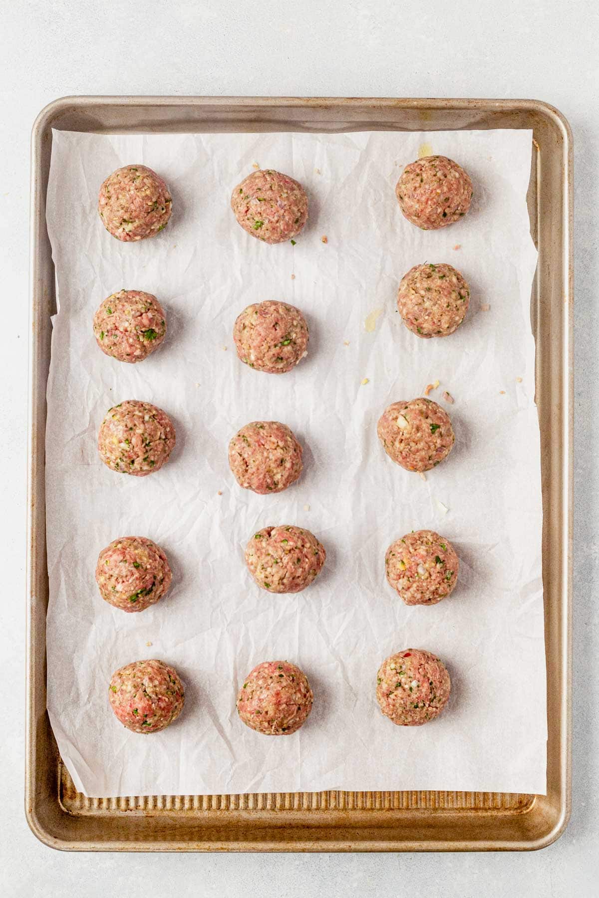 uncooked meatballs on a baking sheet