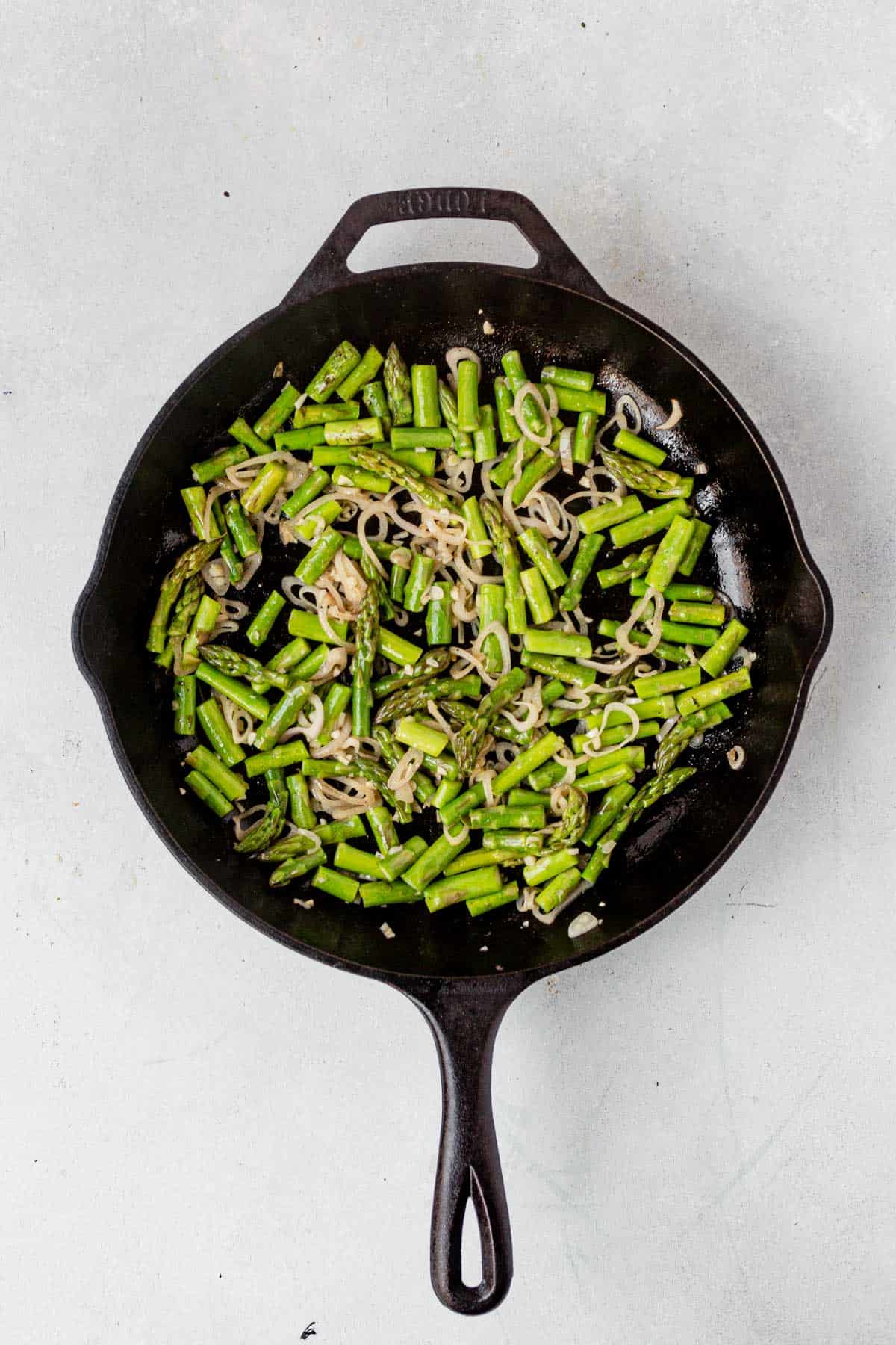 sauteed asparagus and shallots in a cast iron skillet
