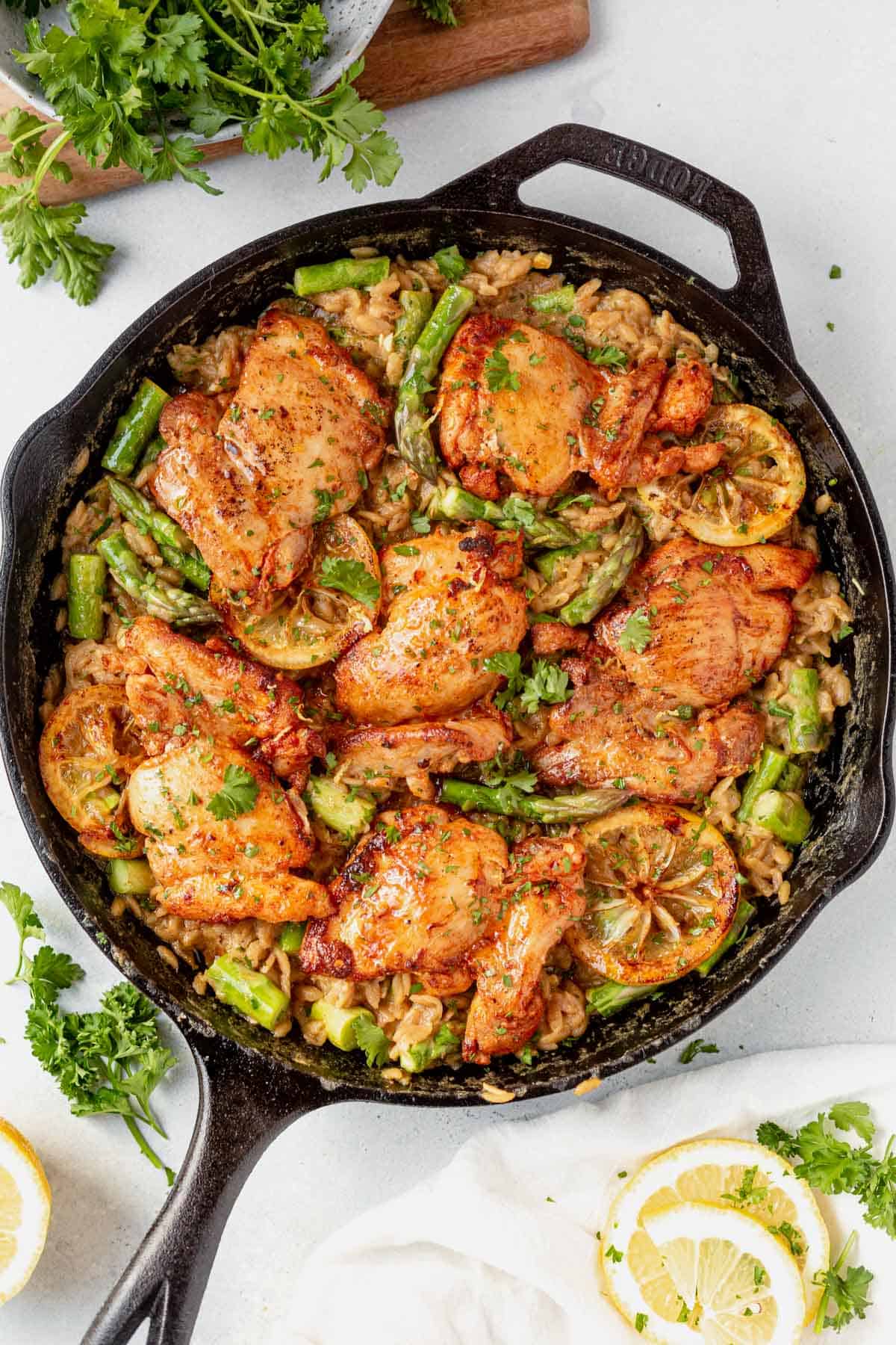 lemon orzo chicken with fresh herbs in a cast iron skillet