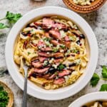 steak alfredo in a bowl with balsamic glaze and blue cheese.