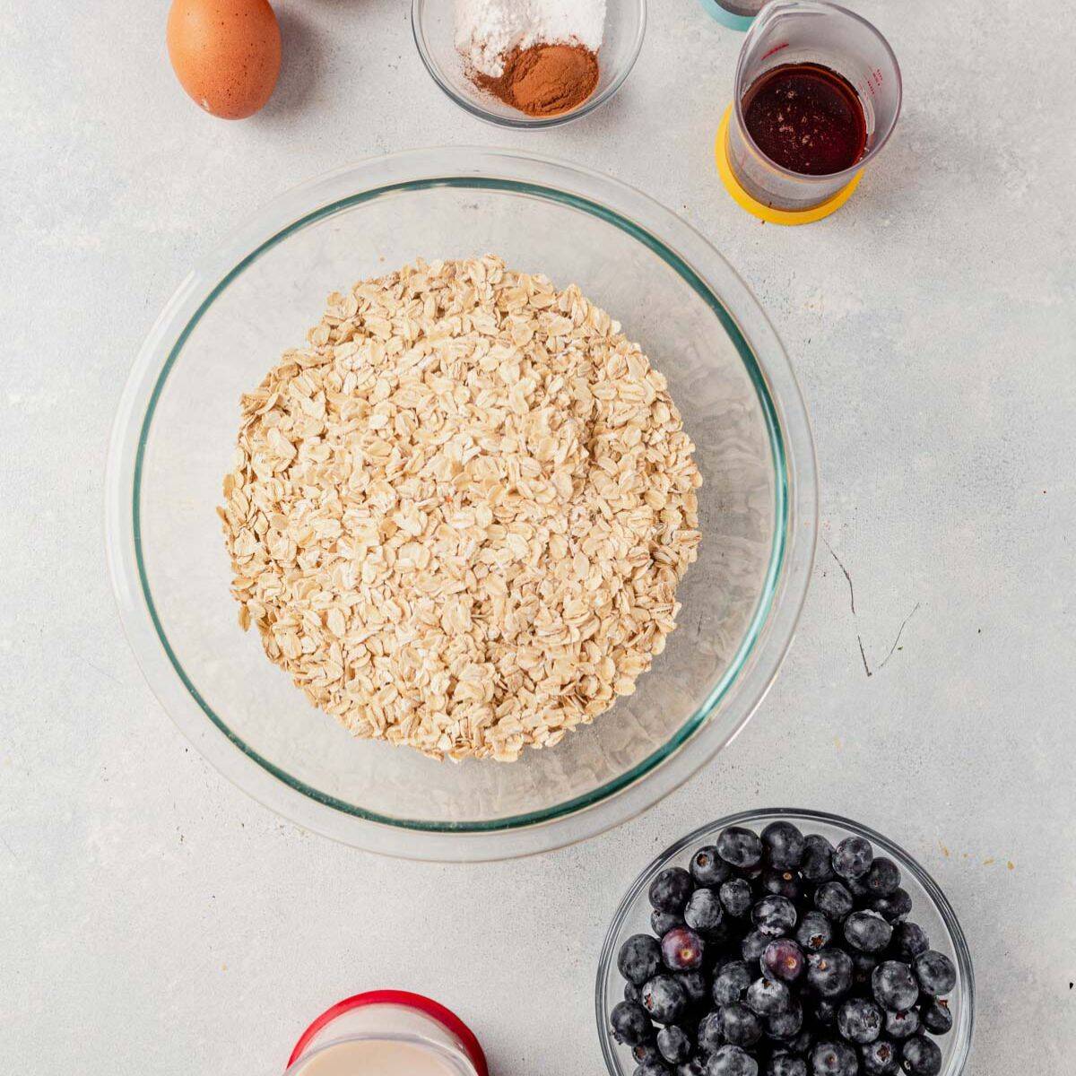 ingredients for healthy baked blueberry oatmeal separated into containers on a counter