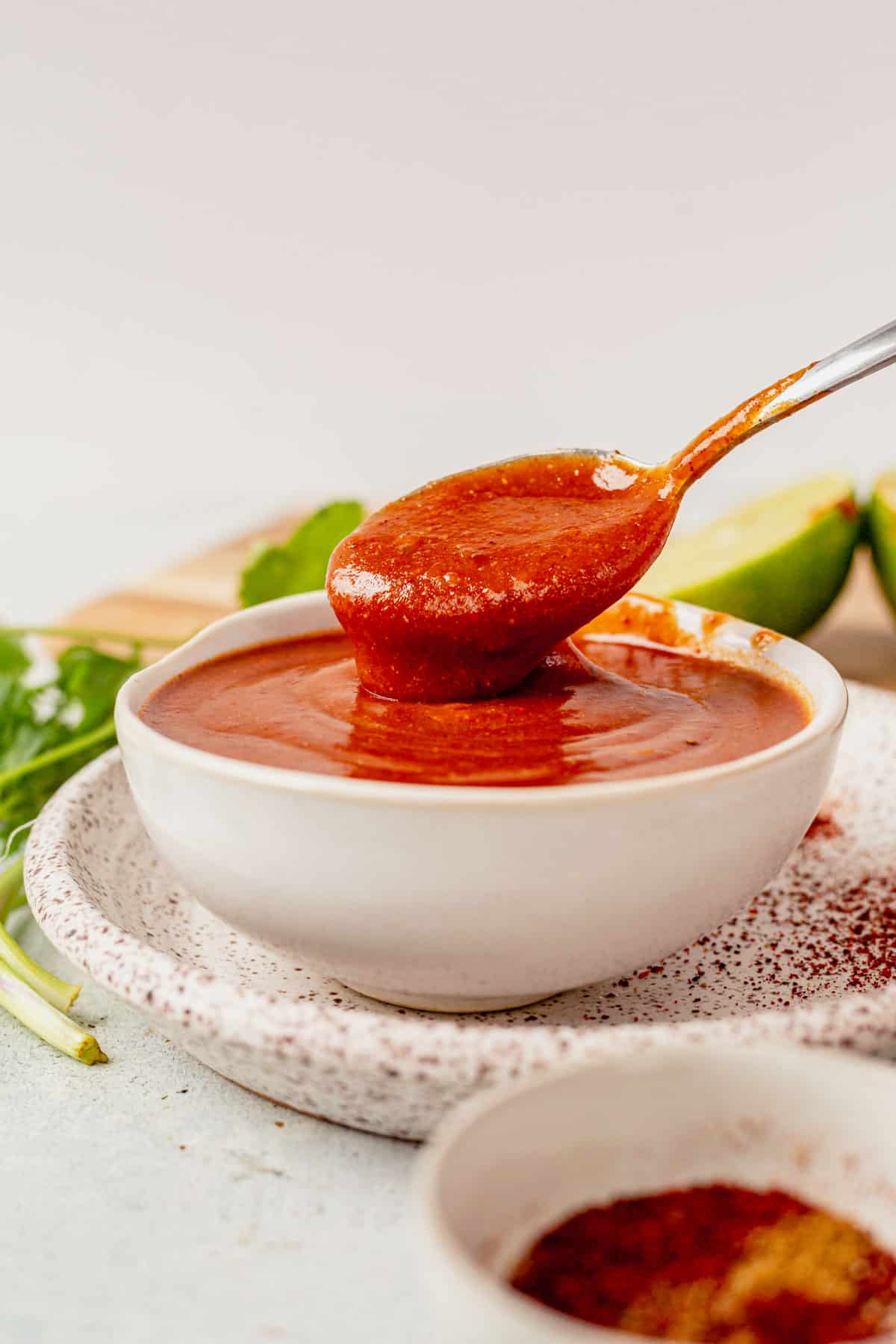 spooning gluten free enchilada sauce out of a bowl