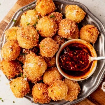 fried goat cheese balls on a serving platter with hot honey sauce