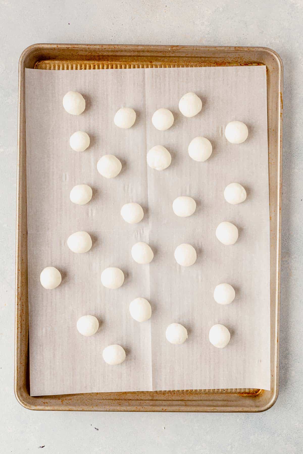goat cheese balls on a parchment-lined baking sheet