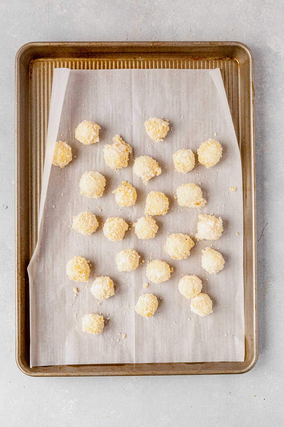breaded goat cheese balls on a baking sheet before frying