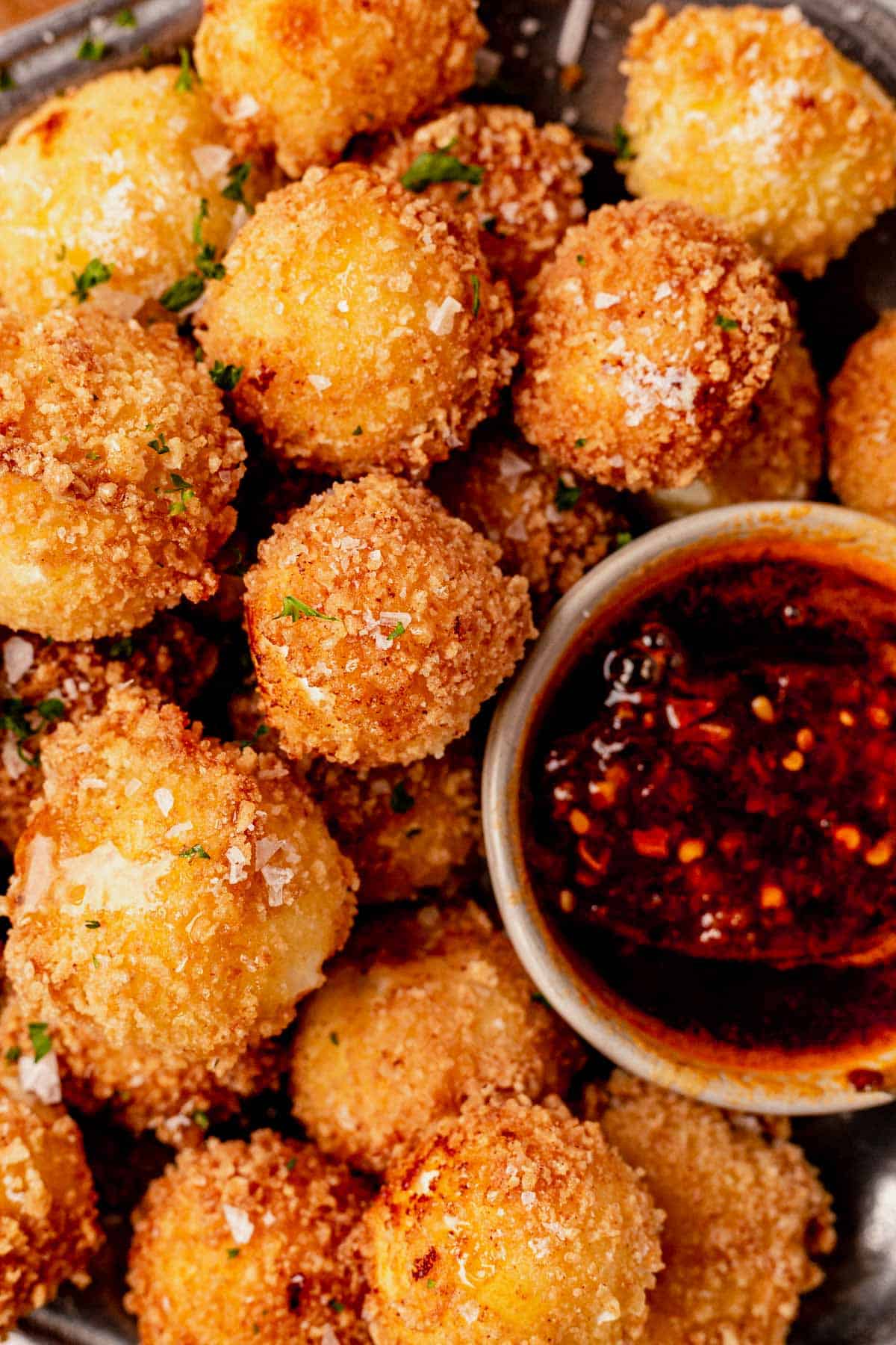 a plate of friend goat cheese balls with hot honey sauce
