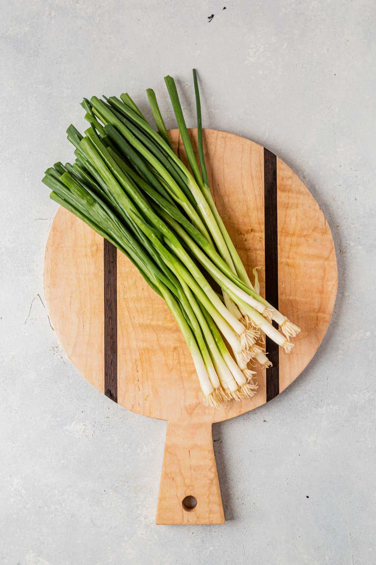 a bunch of green onions on a cutting board