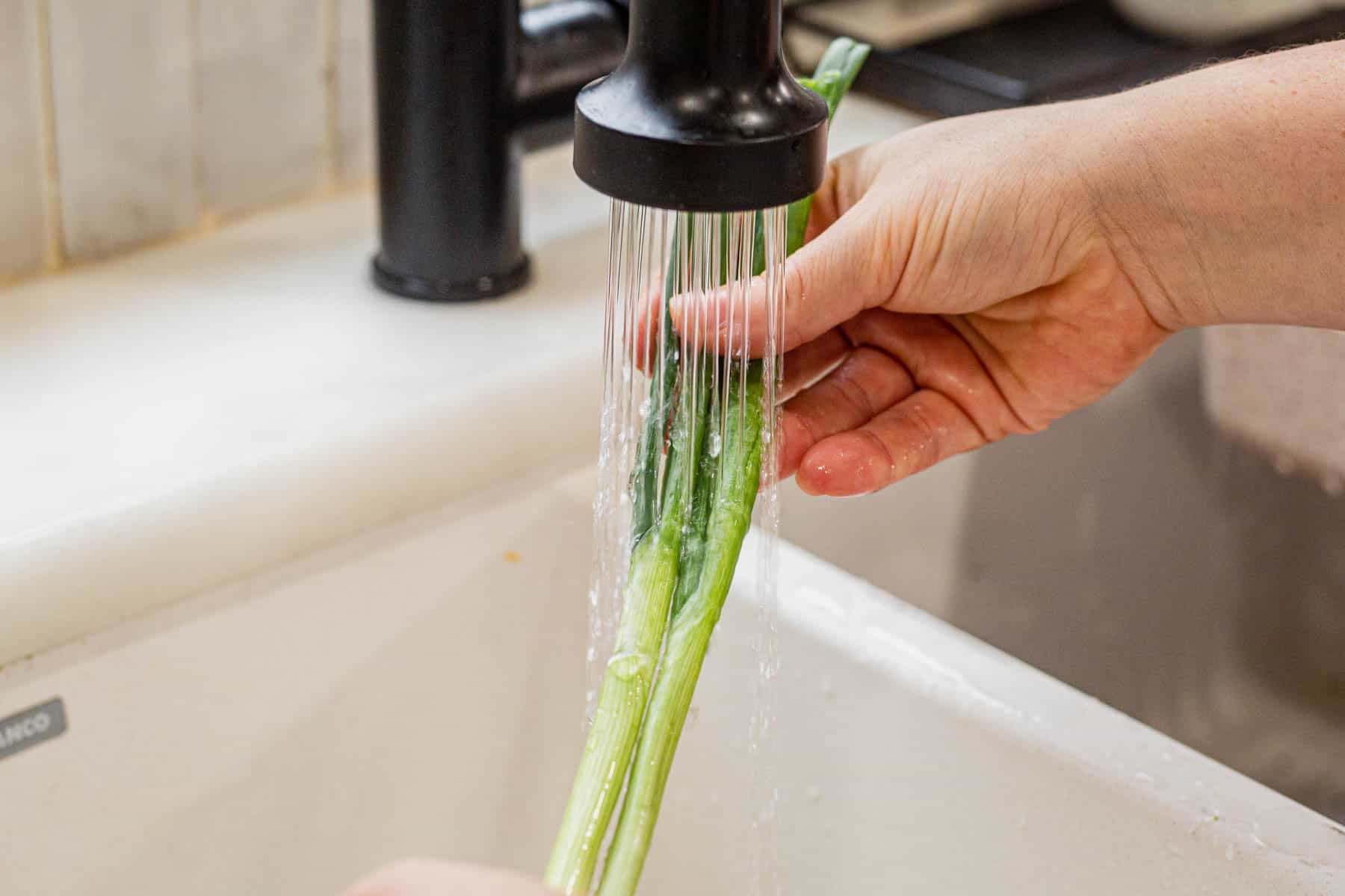 rinsing green onions under water