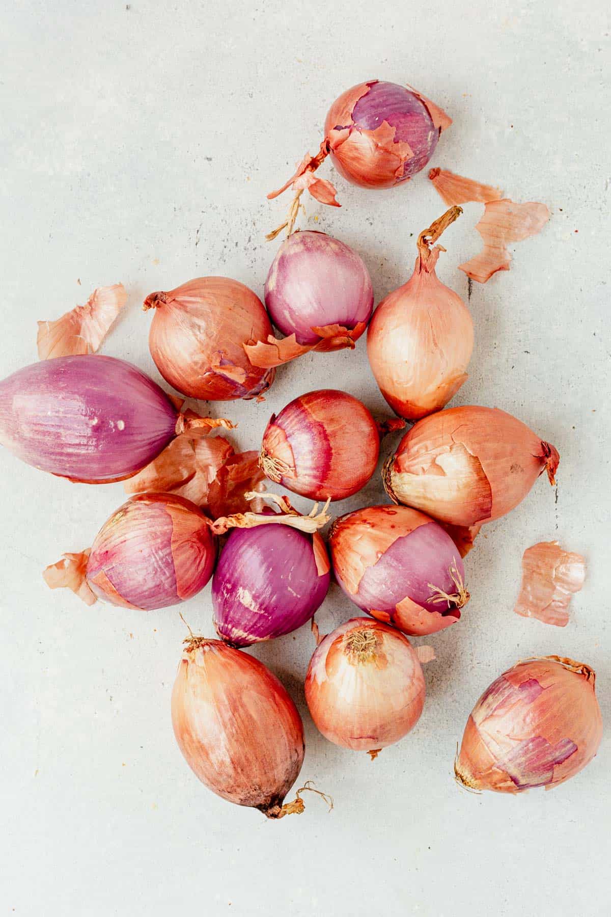 10 whole shallots laying on a countertop