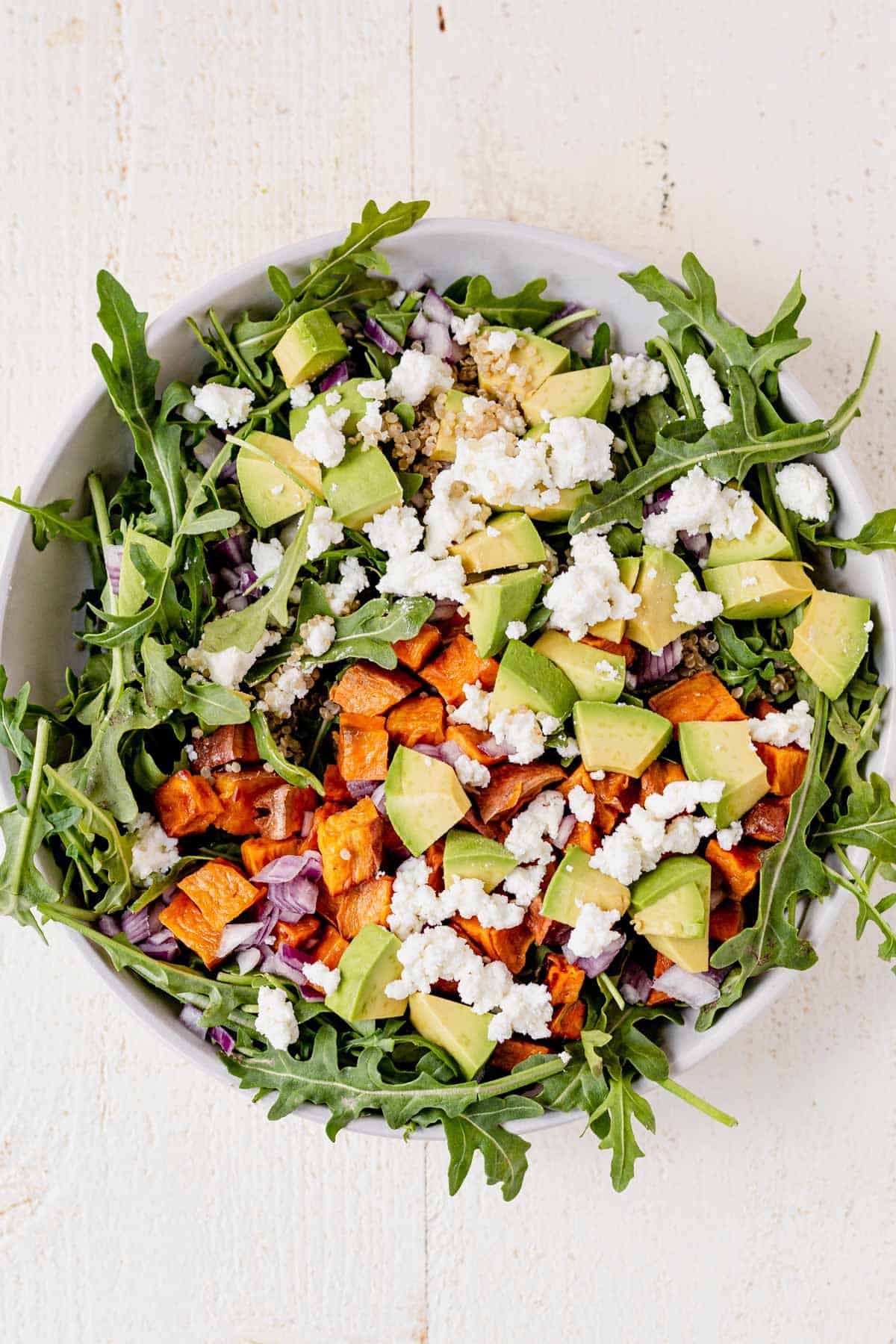 sweet potatoes, avocado, goat cheese, red onion on top of arugula
